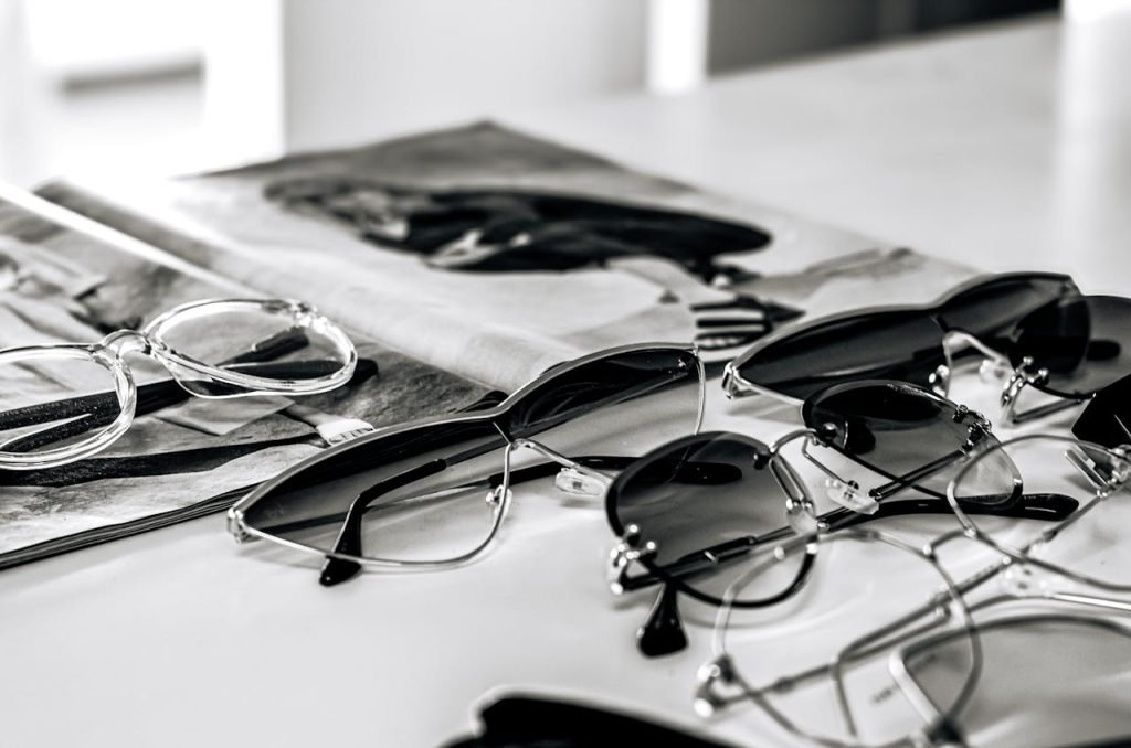 Stylish sunglasses arranged on a glossy magazine in a sleek black and white composition.
