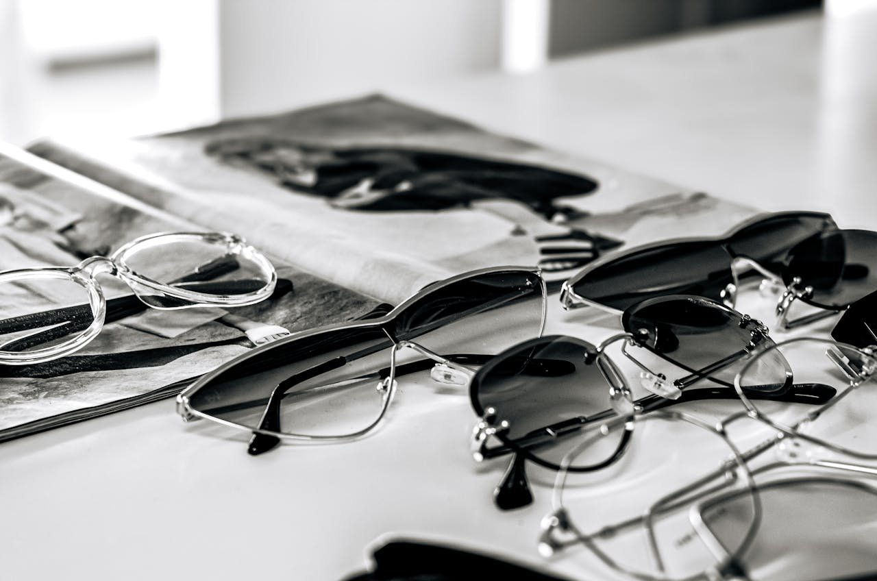 Stylish sunglasses arranged on a glossy magazine in a sleek black and white composition.