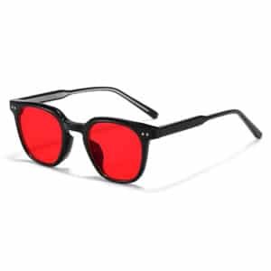 A slightly angled, three-quarter view of black-framed red light glasses for sleep, resting on a plain white background.
